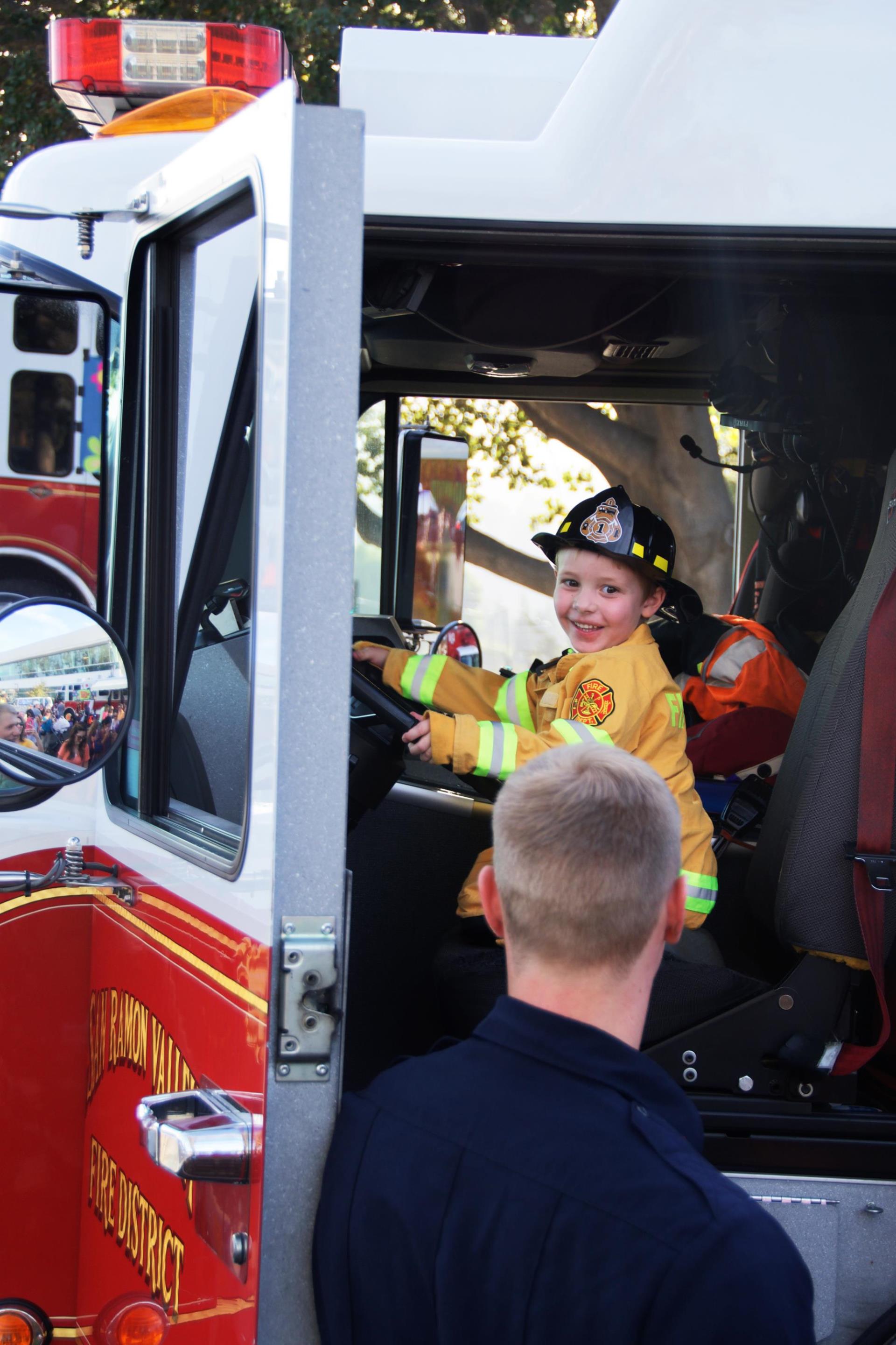 Kid dressed up as Firefighter in engine